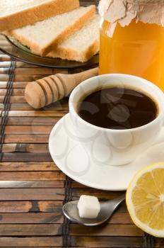 coffee, honey and bread on straw table