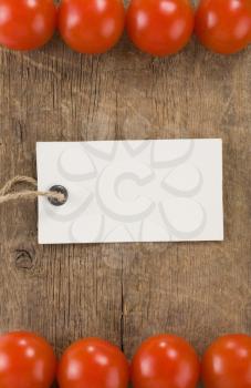 price tag and tomato vegetable over wood background texture