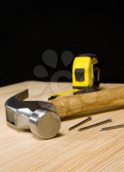 hammer and tape measure on wooden brick