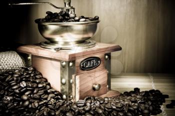 coffee grinder, beans and pot on sacking on sepia