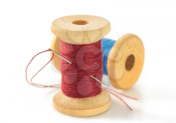 spool of thread and needle isolated on white background