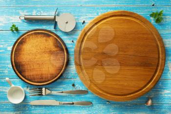 pizza cutting board and utensils at wooden table