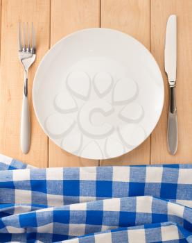 kitchen utensils and cloth napkin on wooden background