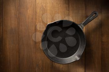 frying pan  on wooden background texture