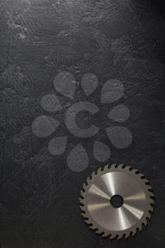 circular saw blade at black background texture
