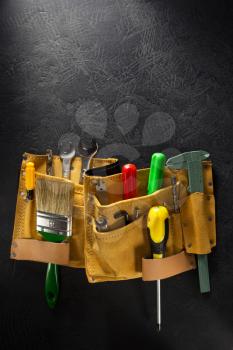 tools and instruments in belt on black background