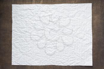 empty checked wrinkled paper at wooden background