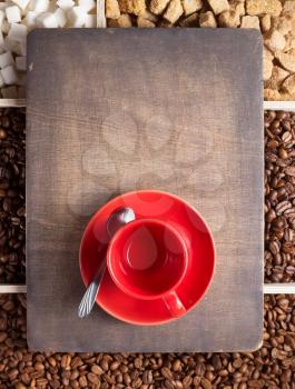 empty cup of coffee and beans on wooden tray background, top view