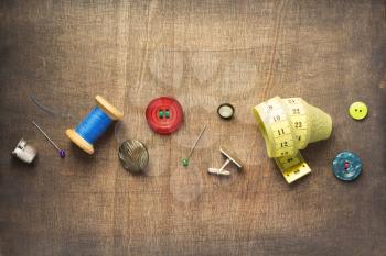 sewing tools and accessories on wooden table background