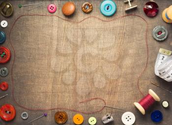 sewing tools and accessories on wooden table background, top view