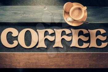 cup of coffee and letters on wooden table background, top view