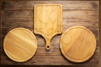 pizza cutting board at rustic wooden plank board background, top view