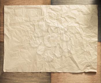 wrinkled paper at wooden surface background