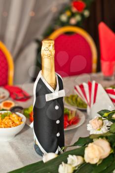 Suit of the groom on a bottle with champagne.
