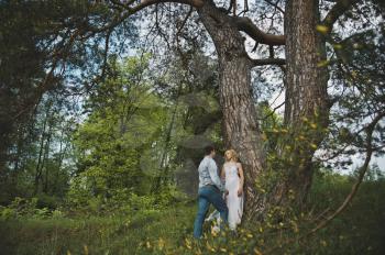 Newly-married couple in the wood about a tree.