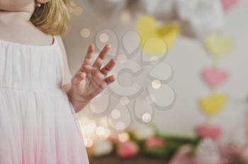 The child licks his fingers after sweet cake.