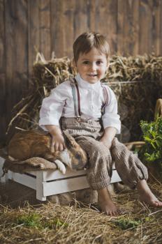 Portrait of little boy playing with a rabbit.