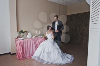 The couple in beautiful outfits sitting at the beautiful table.