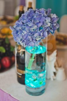Vase with forget-me-nots on the table.