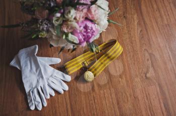 Festive white gloves about a bouquet of flowers.