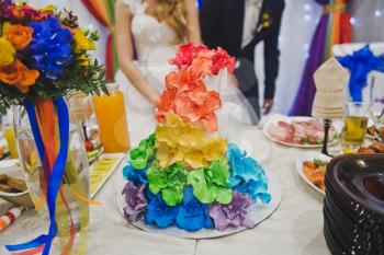 Cake decorated with flowers of all colors of the rainbow.