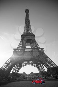 summer sunset vintage red car stands on the Champ de Mars Eiffel Tower. black and white photo