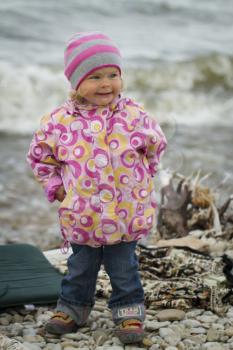 Girl in the autumn at the sea . walking on rocks in the ocean background