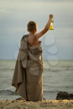 translation of boy dressed in clothing of the ancient Greek time. It should be on the beach