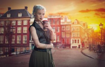 girl with blue hair drinks coffee on a street in Amsterdam, Netherlands