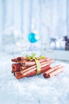 cinnamon sticks and christmas decoration on snow
