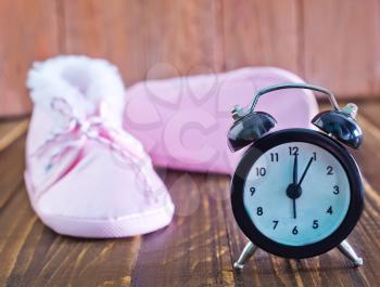 baby shoes and clock on a table
