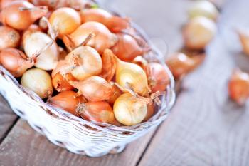 raw onion in basket and on a table