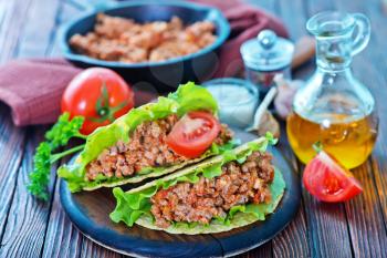 taco with meat and tomato on a table