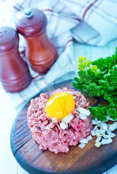 minced meat with yolk on the board
