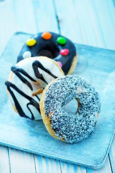 sweet donuts on plate and on a table