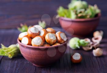 Filtered image of Hazelnuts in a wooden bowl on rustic background