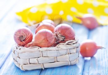 raw onion in basket and on a table