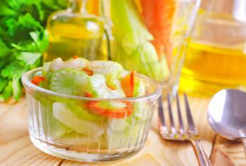 fresh salad with carrot and celery, salad in glass bowl