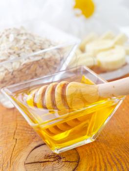 Honey in the glass bowl on the wooden table