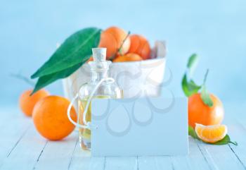 fresh tangerines and oil in bottle and on a table