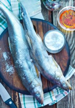 fresh fish on wooden board and on a table