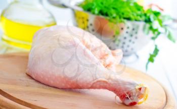 Raw chicken and knife on the wooden board