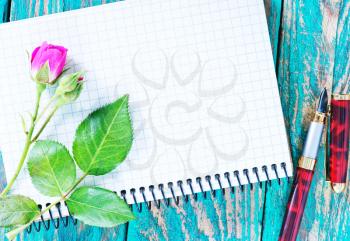 rose and note on the wooden table