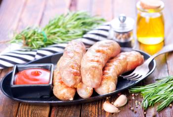 baked sausages on metal plate and on a table