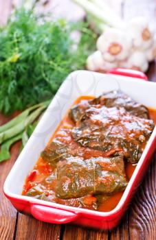 dolma with sauce in the bowl and on a table