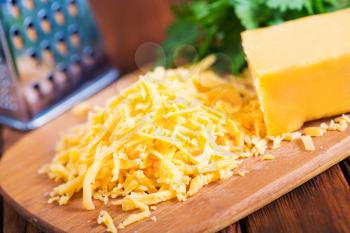 cheddar cheese on board and on a table