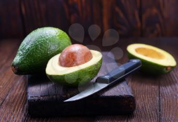 fresh avocado on wooden board and on a table