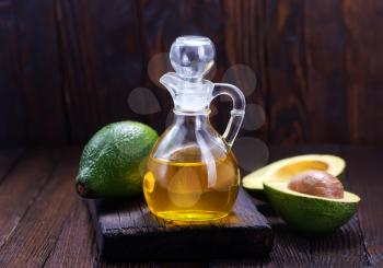 avocado oil in glass and on a table