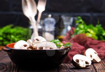 raw mushroom in bowl and on a table