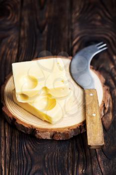cheese and knife on wooden board and on a table